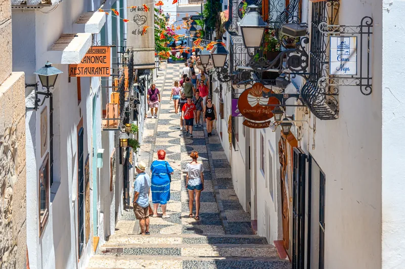 Cobbled street with whitewashed houses and shops in Altea's old town