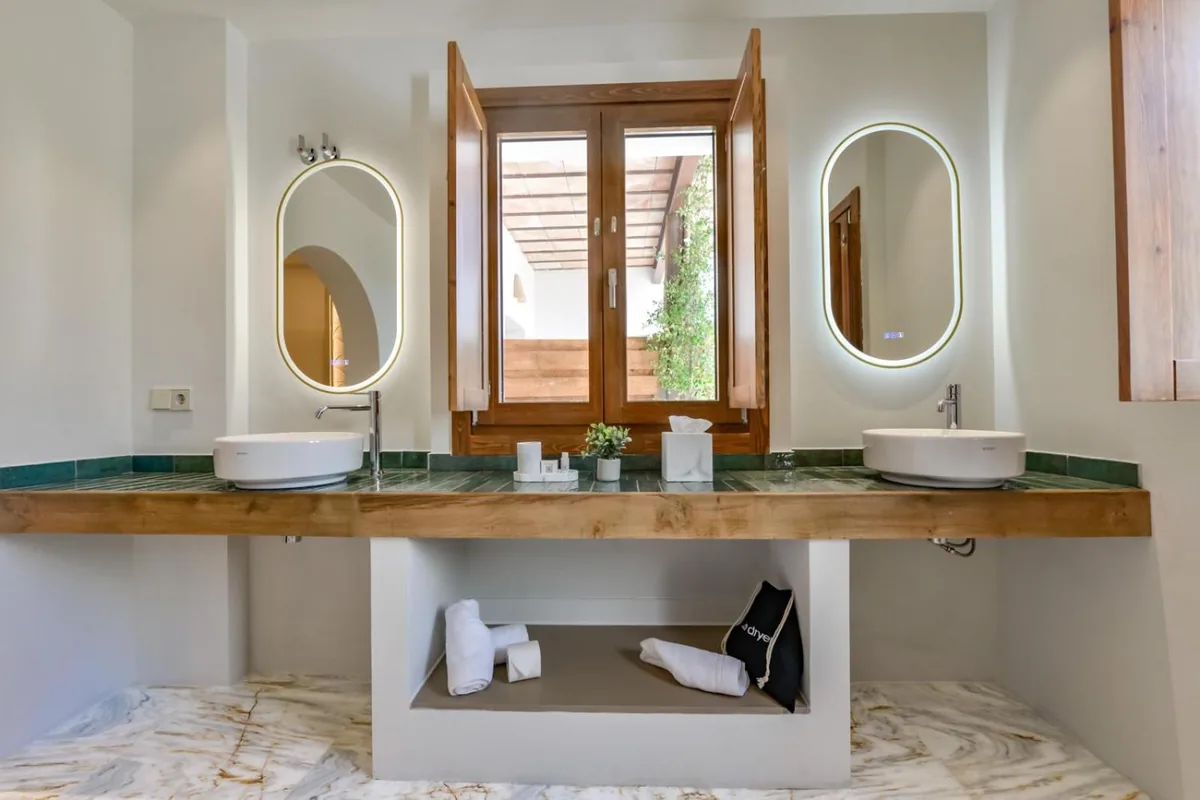 Suite bathroom with double washbasins and illuminated mirrors at Las Torres