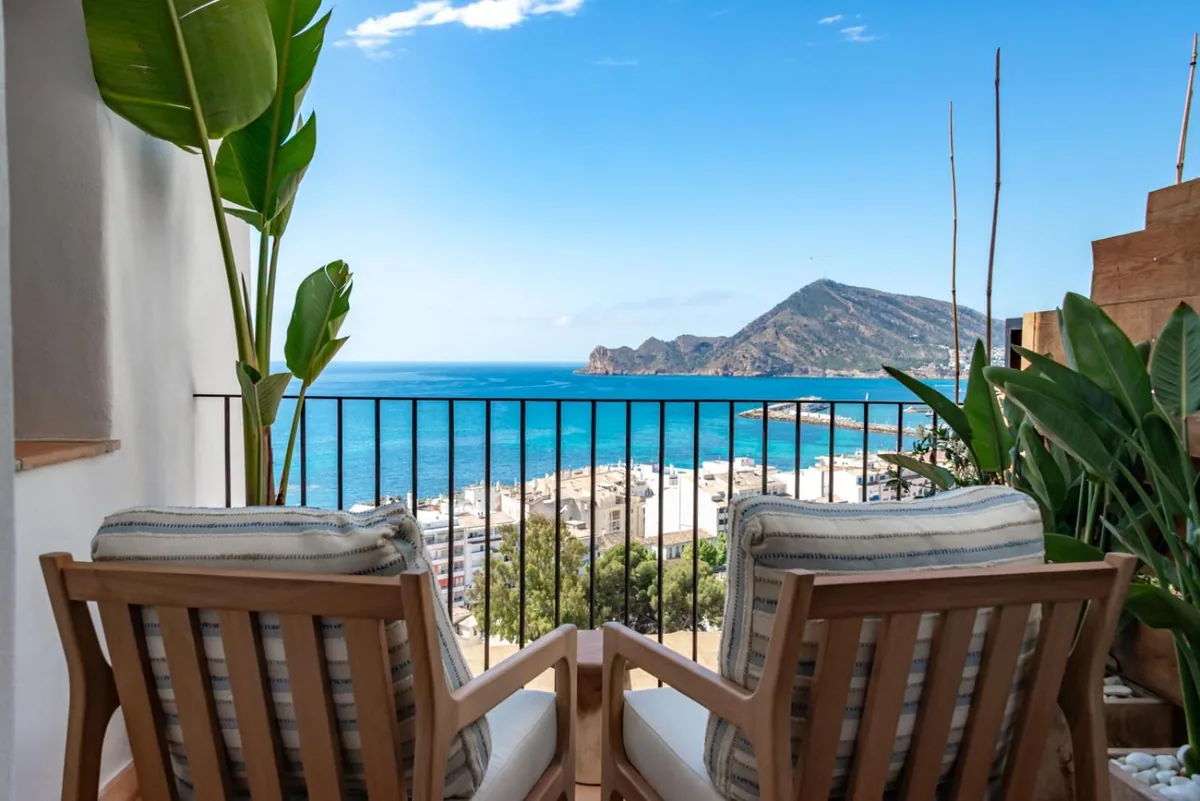 Two wooden chairs overlooking the bay from a Suite balcony at Las Torres