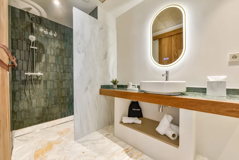 Suite bathroom with a washbasin and green-tiled walk-in shower at Las Torres